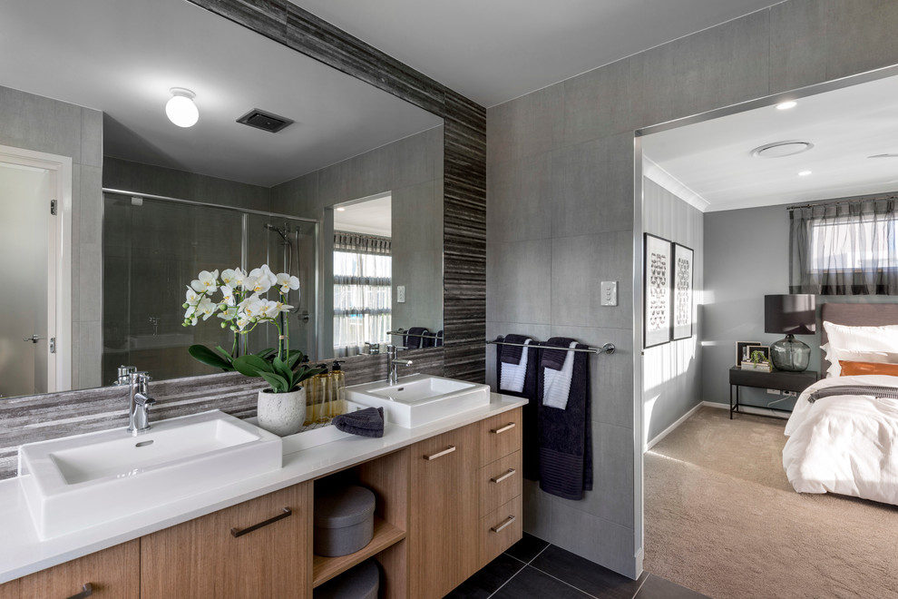 Photo of a medium sized contemporary ensuite bathroom in Brisbane with flat-panel cabinets, light wood cabinets, a corner shower, a one-piece toilet, black tiles, ceramic tiles, grey walls, ceramic flooring, a vessel sink and engineered stone worktops.