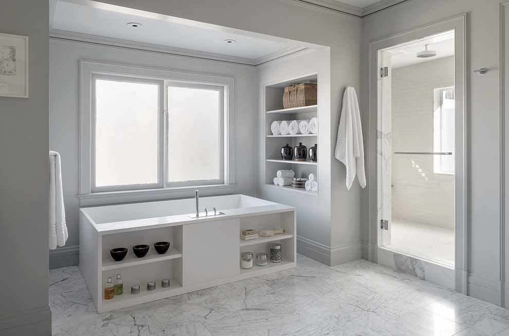 Idée de décoration pour une grande salle de bain principale tradition avec un placard sans porte, des portes de placard blanches, une baignoire indépendante, un sol en marbre et un plan de toilette en marbre.