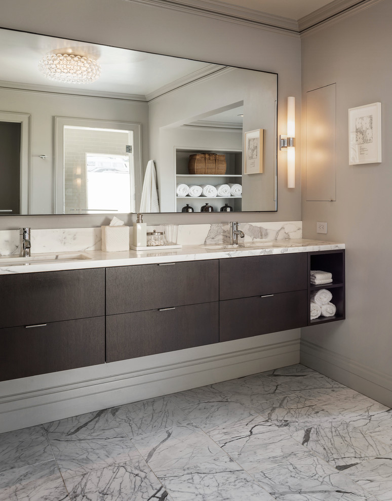 На фото: большая ванная комната в стиле неоклассика (современная классика) с плоскими фасадами, белыми фасадами, отдельно стоящей ванной, унитазом-моноблоком, плиткой из листового камня, серыми стенами, мраморным полом, врезной раковиной и мраморной столешницей
