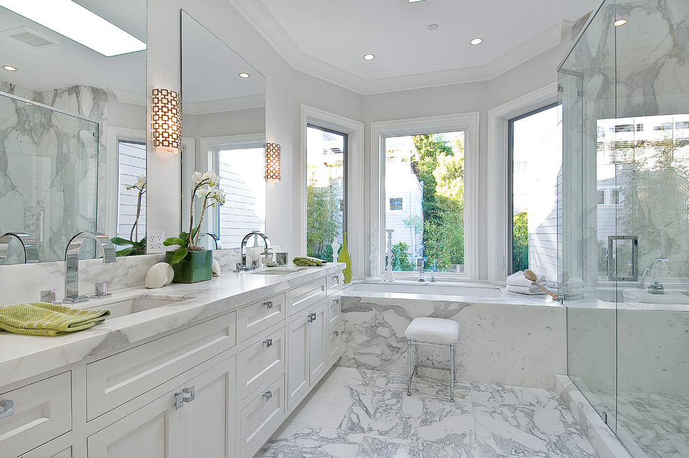Inredning av ett klassiskt badrum, med ett undermonterad handfat, skåp i shakerstil, vita skåp, ett undermonterat badkar, en dusch i en alkov, vit kakel och grå väggar