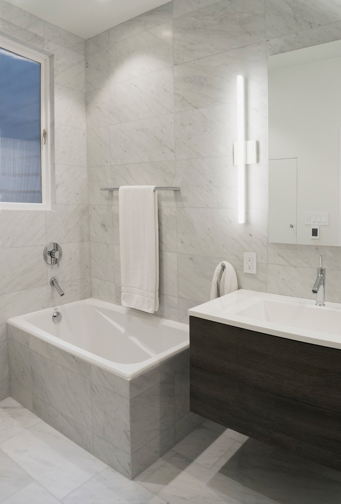 Foto di una stanza da bagno padronale moderna di medie dimensioni con ante lisce, ante marroni, vasca da incasso, doccia alcova, WC monopezzo, piastrelle in pietra, pareti bianche, pavimento in marmo e lavabo integrato