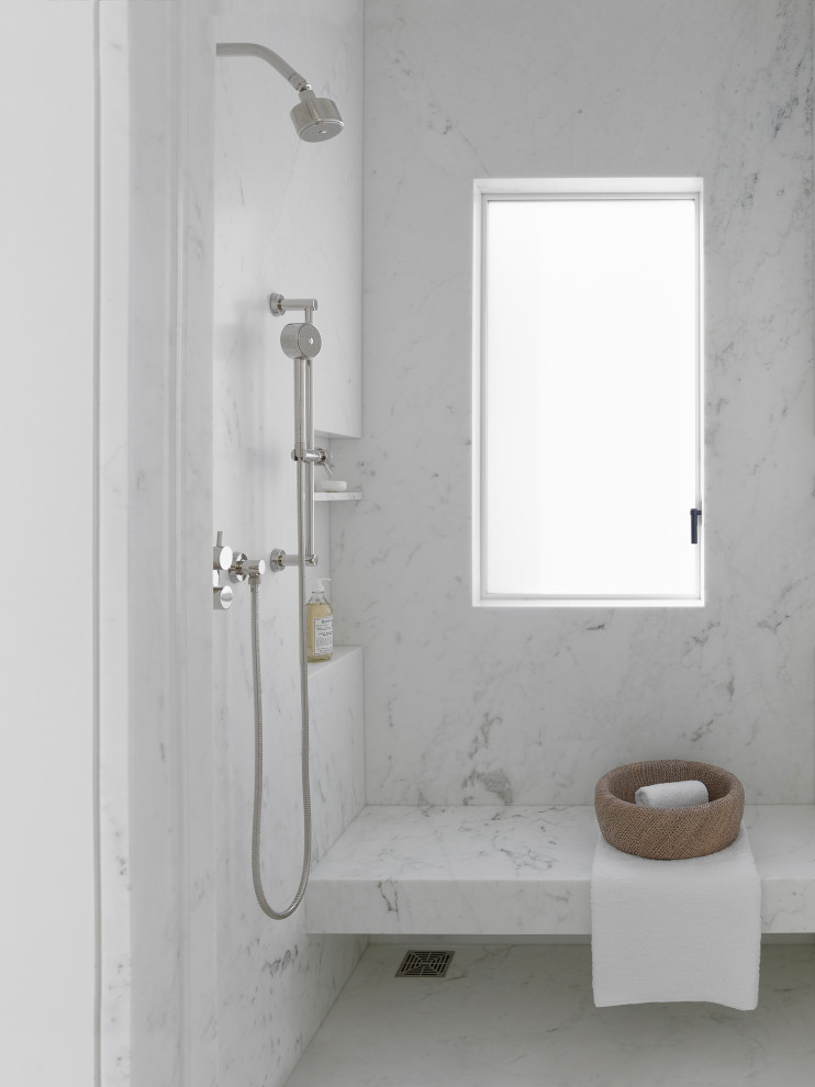 На фото: огромная главная ванная комната в стиле модернизм с плоскими фасадами, белыми фасадами, биде, белой плиткой, мраморной плиткой, белыми стенами, светлым паркетным полом, монолитной раковиной, мраморной столешницей, бежевым полом, открытым душем, белой столешницей и душем в нише