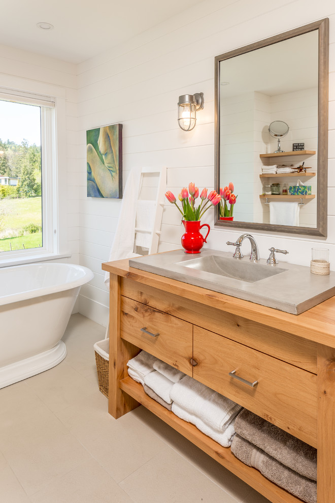 Inspiration for a farmhouse beige floor freestanding bathtub remodel in Vancouver with medium tone wood cabinets, white walls, a drop-in sink, wood countertops, brown countertops and flat-panel cabinets