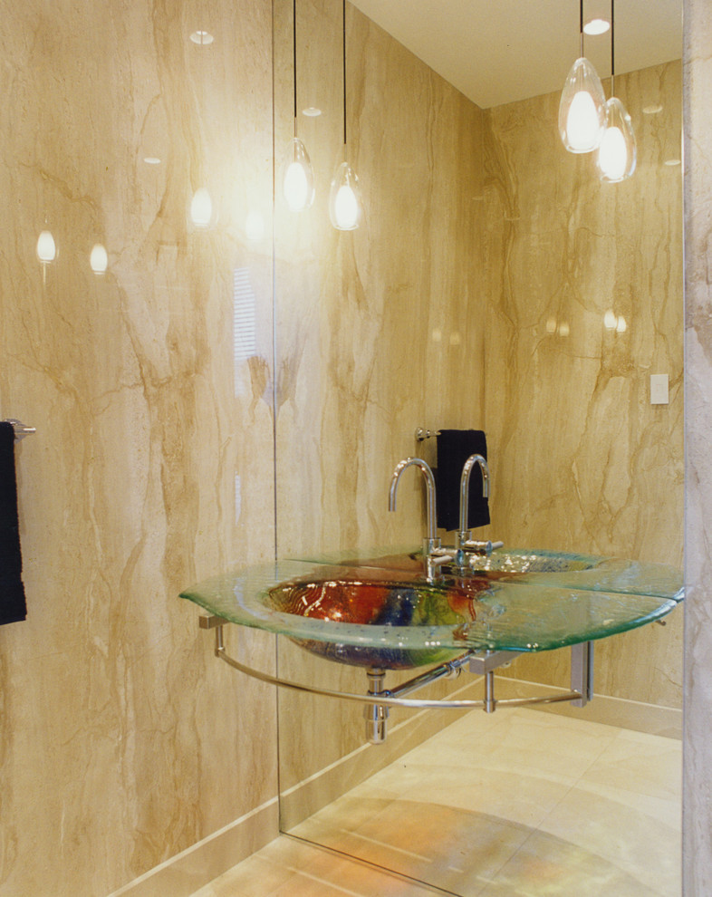 Foto de cuarto de baño moderno pequeño con paredes beige, suelo de piedra caliza, lavabo suspendido y encimera de vidrio