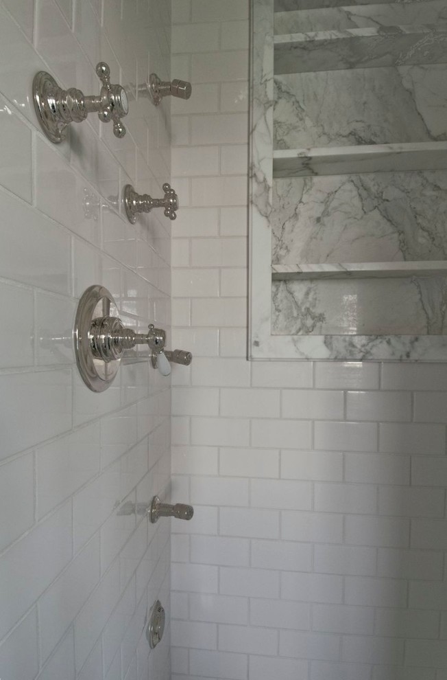 Cette image montre une salle de bain principale design de taille moyenne avec une baignoire encastrée, un carrelage gris, un carrelage blanc, des carreaux de porcelaine, un mur blanc, un sol en carrelage de terre cuite, un lavabo encastré, un plan de toilette en marbre et un sol multicolore.