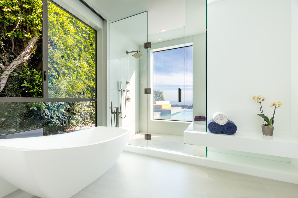 Exempel på ett modernt en-suite badrum, med ett fristående badkar, en dusch i en alkov, vit kakel, vita väggar, grått golv och dusch med gångjärnsdörr