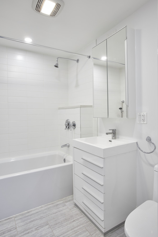 Mittelgroßes Modernes Duschbad mit flächenbündigen Schrankfronten, weißen Schränken, Badewanne in Nische, Duschnische, Toilette mit Aufsatzspülkasten, weißen Fliesen, Porzellanfliesen, weißer Wandfarbe, Porzellan-Bodenfliesen, integriertem Waschbecken, grauem Boden, Duschvorhang-Duschabtrennung, weißer Waschtischplatte, Einzelwaschbecken und eingebautem Waschtisch in New York