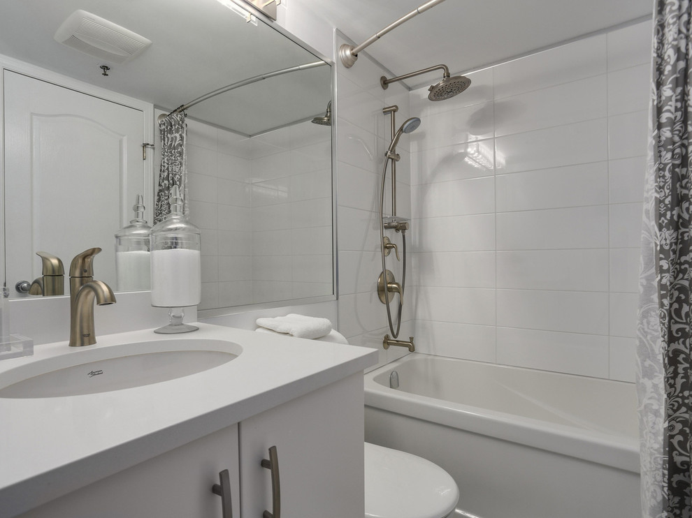 На фото: ванная комната среднего размера в современном стиле с плоскими фасадами, белыми фасадами, ванной в нише, душем над ванной, раздельным унитазом, белыми стенами, полом из керамической плитки, душевой кабиной, врезной раковиной и столешницей из ламината
