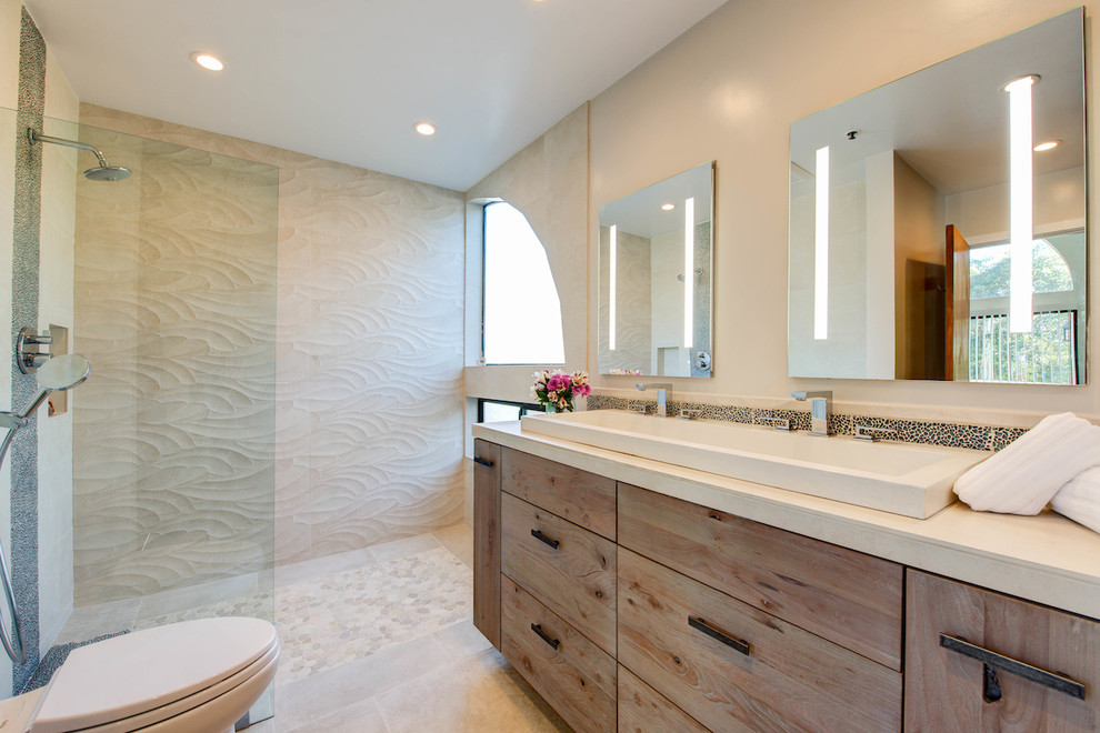 Design ideas for a medium sized beach style ensuite bathroom in San Francisco with flat-panel cabinets, distressed cabinets, a built-in shower, a one-piece toilet, beige tiles, porcelain tiles, beige walls, porcelain flooring, a trough sink and tiled worktops.