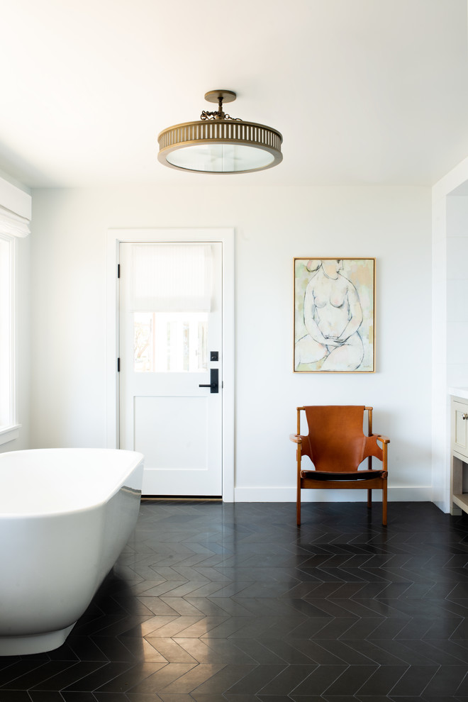 Idéer för maritima badrum, med ett fristående badkar, vita väggar och svart golv