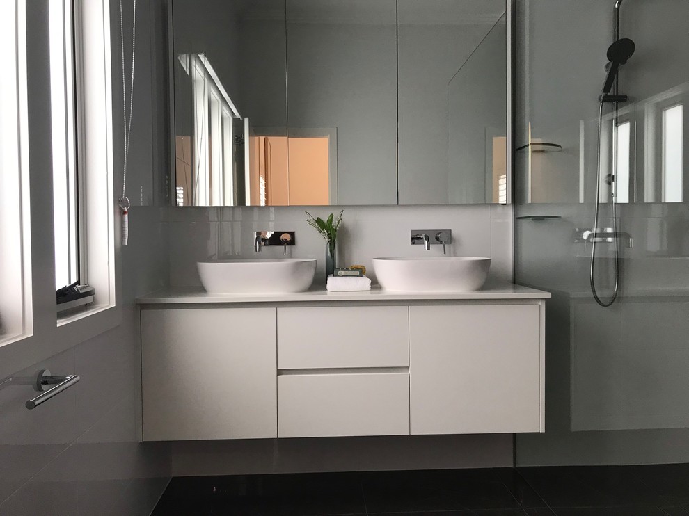 Cette image montre une petite salle de bain principale design avec des portes de placard blanches, un carrelage blanc, un carrelage de pierre, un plan de toilette en granite et aucune cabine.