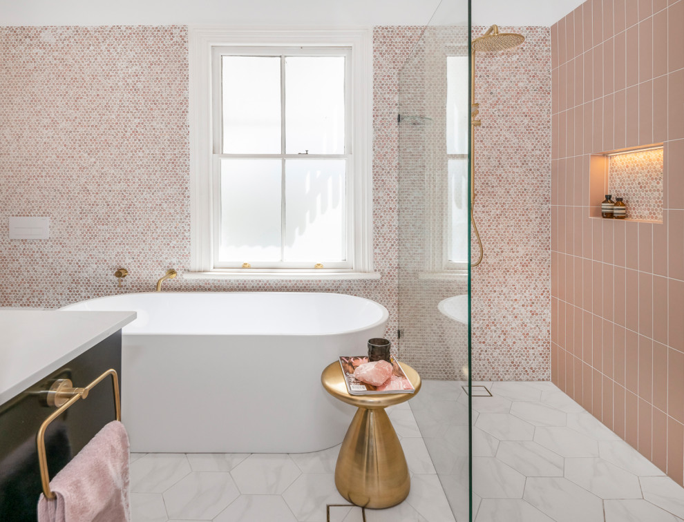 На фото: большая главная ванная комната в современном стиле с фасадами островного типа, черными фасадами, отдельно стоящей ванной, открытым душем, инсталляцией, розовой плиткой, плиткой мозаикой, розовыми стенами, полом из керамической плитки, настольной раковиной, мраморной столешницей, черным полом, открытым душем, белой столешницей, нишей, тумбой под две раковины и подвесной тумбой с
