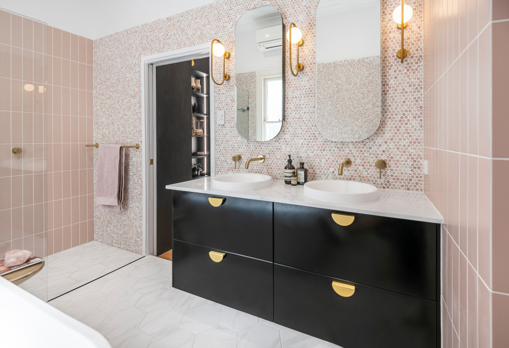 Стильный дизайн: большая главная ванная комната в современном стиле с фасадами островного типа, черными фасадами, отдельно стоящей ванной, открытым душем, инсталляцией, розовой плиткой, плиткой мозаикой, розовыми стенами, полом из керамической плитки, настольной раковиной, мраморной столешницей, черным полом, открытым душем, белой столешницей, нишей, тумбой под две раковины и подвесной тумбой - последний тренд