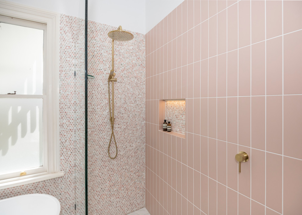 Large contemporary ensuite bathroom in Brisbane with freestanding cabinets, black cabinets, a freestanding bath, a walk-in shower, a wall mounted toilet, pink tiles, mosaic tiles, pink walls, ceramic flooring, a vessel sink, marble worktops, black floors, an open shower, white worktops, a wall niche, double sinks and a floating vanity unit.