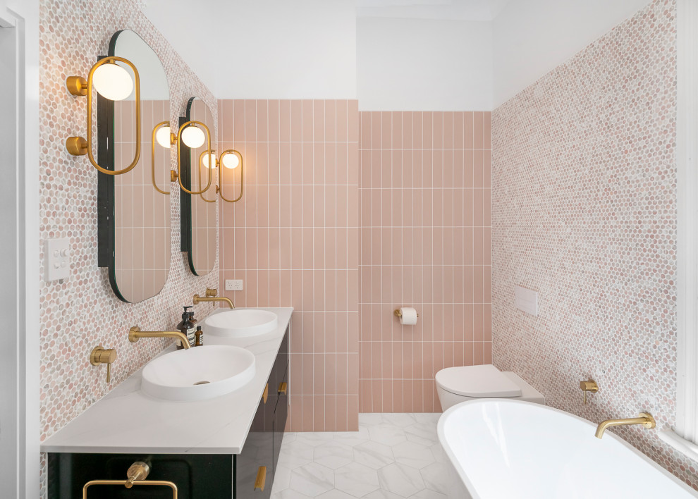 Свежая идея для дизайна: большая главная ванная комната в современном стиле с черными фасадами, отдельно стоящей ванной, открытым душем, инсталляцией, розовой плиткой, плиткой мозаикой, розовыми стенами, полом из керамической плитки, настольной раковиной, мраморной столешницей, черным полом, открытым душем, белой столешницей, нишей, тумбой под две раковины, подвесной тумбой и плоскими фасадами - отличное фото интерьера
