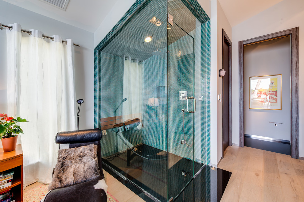 Exemple d'une grande salle de bain tendance avec un mur blanc, parquet clair, une douche d'angle, un carrelage bleu et un carrelage en pâte de verre.