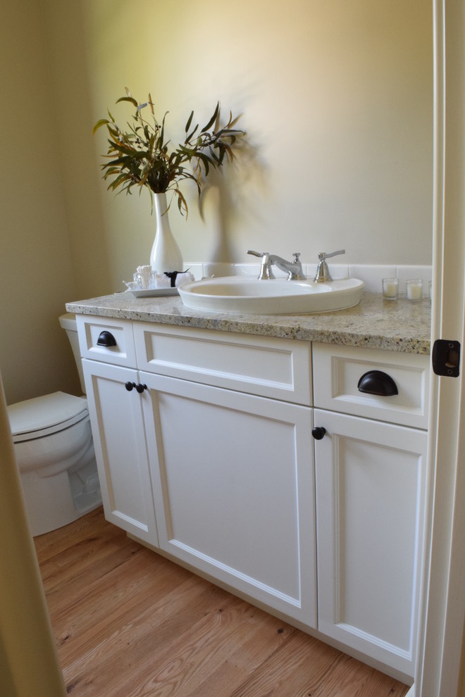 Idéer för att renovera ett litet vintage badrum, med luckor med infälld panel, vita skåp, en toalettstol med separat cisternkåpa, beige väggar, ljust trägolv, ett nedsänkt handfat och granitbänkskiva