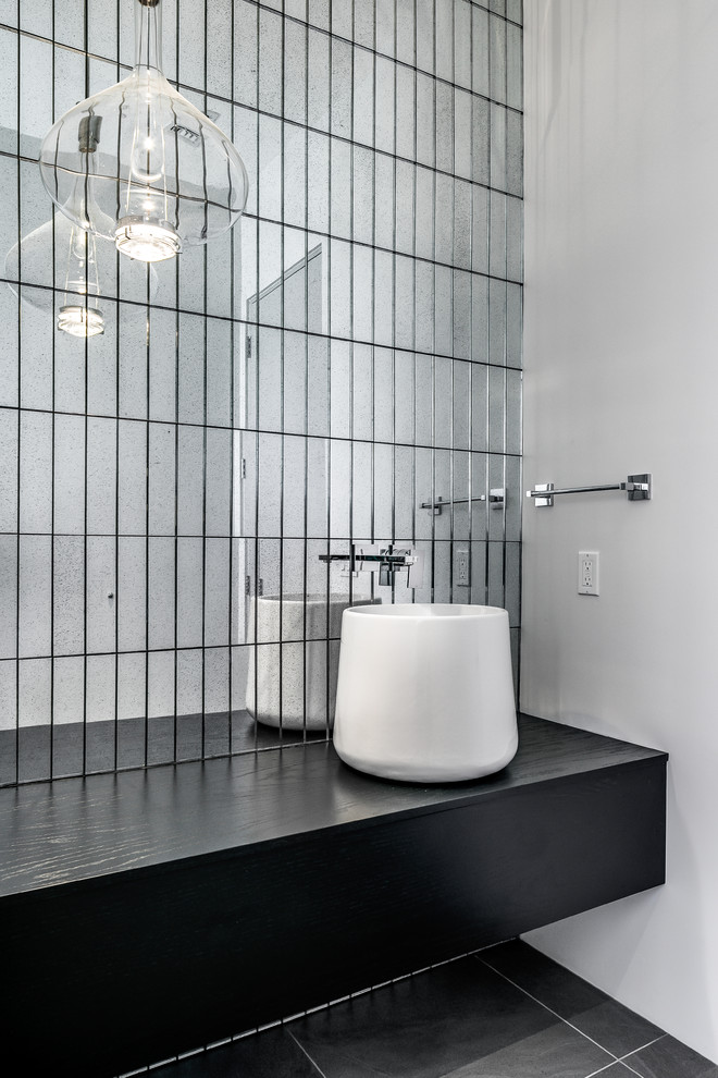 На фото: ванная комната среднего размера в современном стиле с плоскими фасадами, черными фасадами, зеркальной плиткой, белыми стенами, полом из керамогранита, душевой кабиной, настольной раковиной, столешницей из дерева, серым полом и черной столешницей с