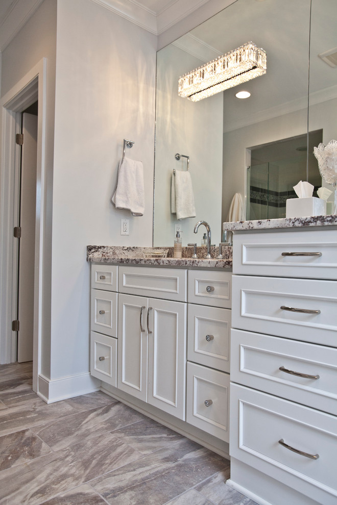 Immagine di una stanza da bagno con doccia tradizionale di medie dimensioni con ante a filo, ante bianche, pareti grigie, pavimento in gres porcellanato, lavabo sottopiano, top in granito, pavimento marrone e top marrone