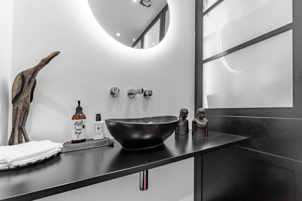 Kleines Modernes Badezimmer mit schwarzen Schränken, Toilette mit Aufsatzspülkasten, Waschtisch aus Holz, rotem Boden, schwarzer Waschtischplatte, Einzelwaschbecken und schwebendem Waschtisch in Kent