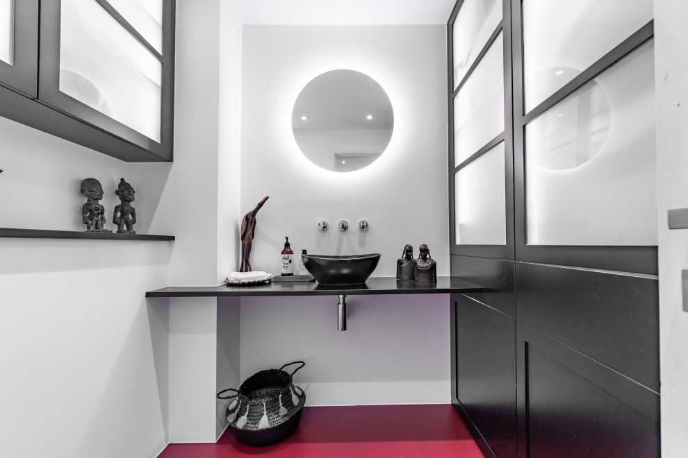 Ispirazione per una piccola stanza da bagno contemporanea con ante nere, WC monopezzo, top in legno, pavimento rosso, top nero, un lavabo e mobile bagno sospeso