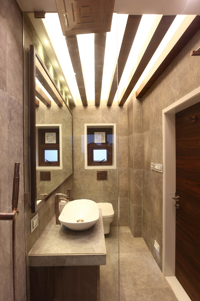 Inspiration för ett litet funkis badrum med dusch, med luckor med lamellpanel, skåp i mellenmörkt trä, en toalettstol med separat cisternkåpa, grå kakel, stenkakel, grå väggar, klinkergolv i keramik och kaklad bänkskiva