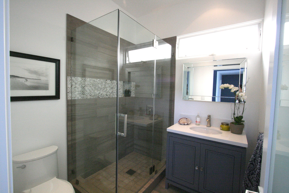 Photo of a medium sized contemporary ensuite bathroom in Los Angeles with a submerged sink, shaker cabinets, grey cabinets, engineered stone worktops, a corner shower, a one-piece toilet, grey tiles, stone tiles, white walls and limestone flooring.