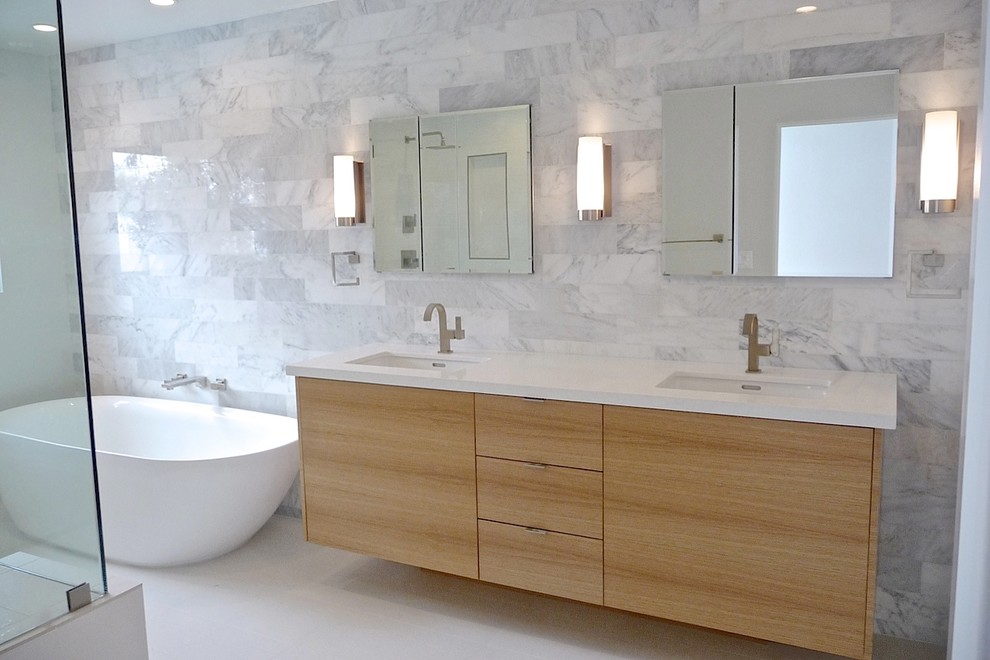 Réalisation d'une salle de bain minimaliste en bois clair avec un placard à porte plane, un plan de toilette en quartz modifié et un carrelage blanc.