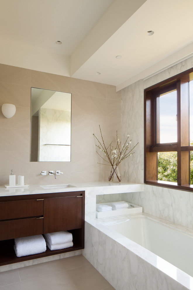 Aménagement d'une salle de bain contemporaine en bois foncé avec un plan de toilette en marbre, un carrelage blanc et des dalles de pierre.