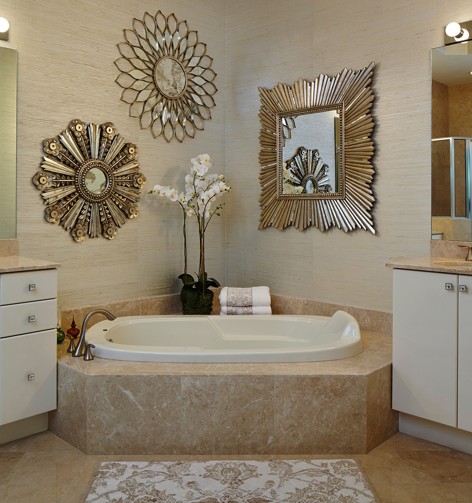 This is an example of a contemporary ensuite bathroom in Miami with flat-panel cabinets, white cabinets, marble worktops, a corner bath, beige tiles, stone slabs, beige walls and marble flooring.