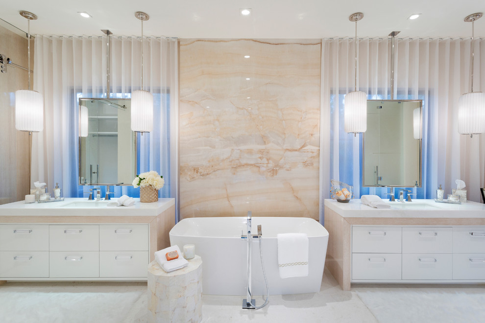 Diseño de cuarto de baño mediterráneo con armarios con paneles lisos, puertas de armario blancas, bañera exenta, baldosas y/o azulejos beige, losas de piedra, lavabo bajoencimera, suelo blanco y encimeras blancas