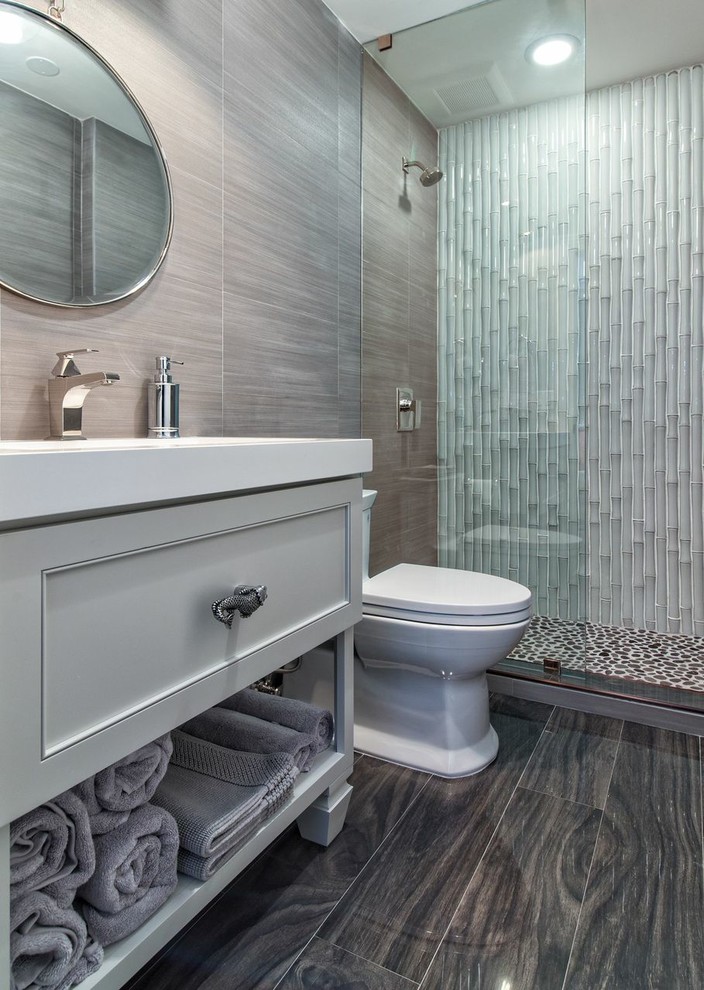 Idéer för mellanstora tropiska badrum med dusch, med luckor med infälld panel, grå skåp, en dusch i en alkov, vit kakel, keramikplattor, bruna väggar, mörkt trägolv, ett undermonterad handfat, bänkskiva i akrylsten och brunt golv