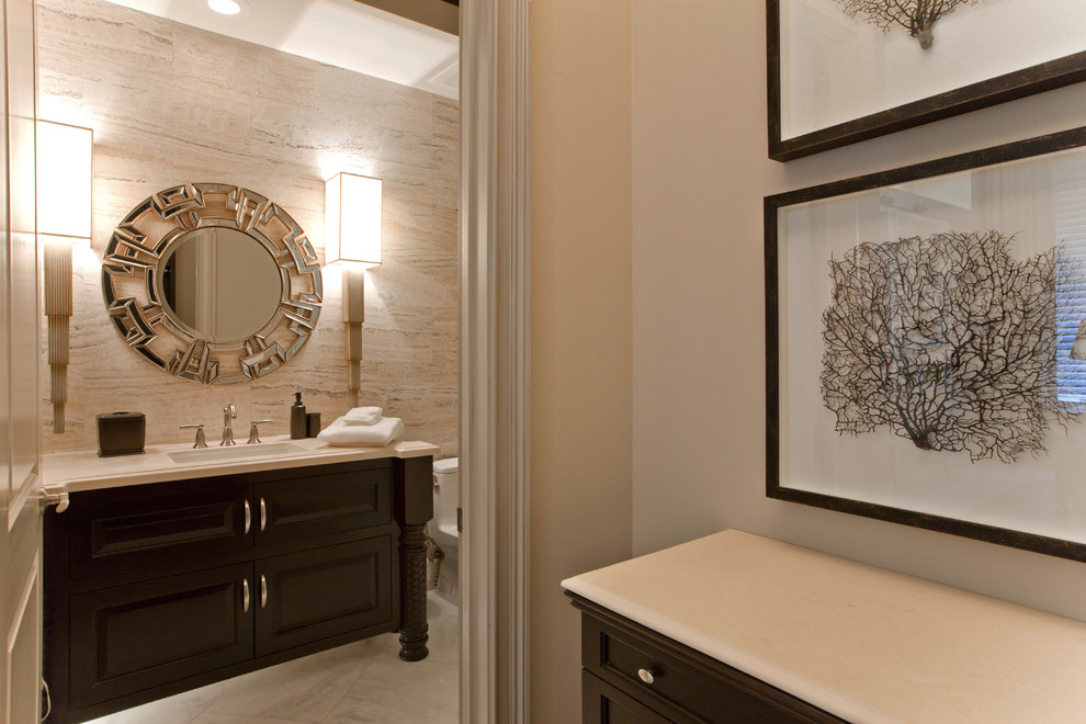 Example of a beach style master beige tile and limestone tile bathroom design in Baltimore with dark wood cabinets, an undermount sink and marble countertops