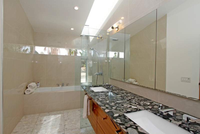 Cette image montre une salle de bain minimaliste avec un placard à porte plane, un plan de toilette en granite, une baignoire posée, une douche ouverte, un lavabo encastré et un sol en terrazzo.