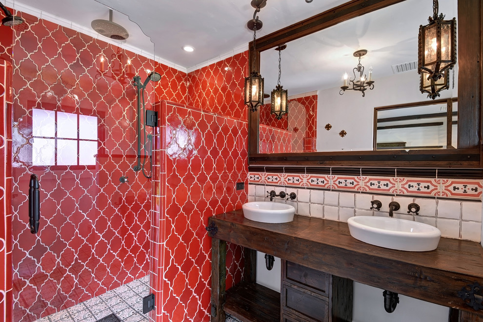 Cette image montre une douche en alcôve méditerranéenne en bois foncé avec un carrelage rouge, un carrelage blanc, une vasque, un plan de toilette en bois, une cabine de douche à porte battante, un plan de toilette marron et un placard à porte shaker.