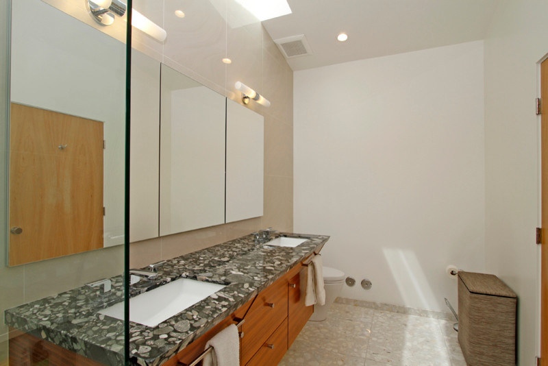 Modernes Badezimmer En Suite mit flächenbündigen Schrankfronten, Granit-Waschbecken/Waschtisch, Terrazzo-Boden und Unterbauwaschbecken in Sonstige