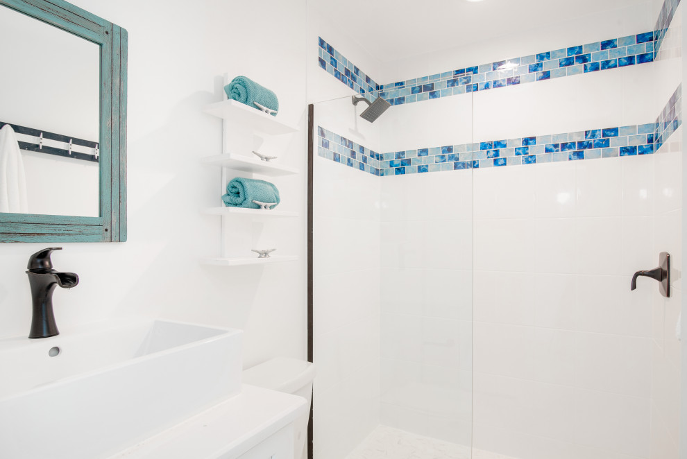 Aménagement d'une salle de bain bord de mer de taille moyenne pour enfant avec un placard à porte shaker, des portes de placard blanches, une douche ouverte, WC à poser, un carrelage multicolore, un carrelage en pâte de verre, un mur blanc, un sol en carrelage de porcelaine, un lavabo encastré, un plan de toilette en quartz modifié, un sol blanc, une cabine de douche à porte coulissante, un plan de toilette blanc, un banc de douche, meuble simple vasque, meuble-lavabo encastré, un plafond en lambris de bois et du lambris de bois.