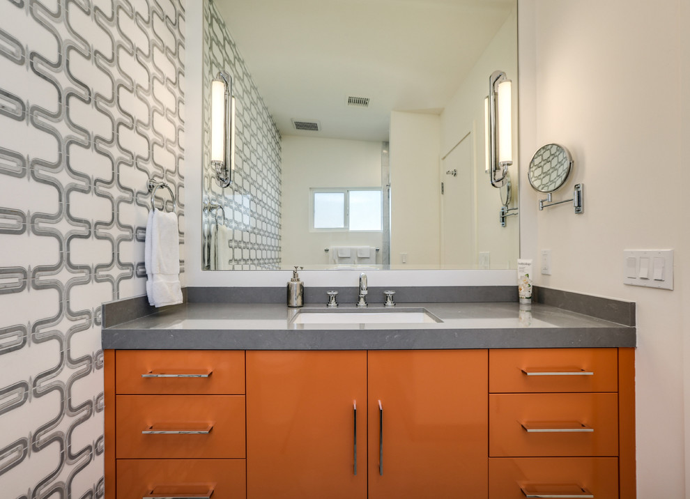 Example of a mid-sized mid-century modern multicolored tile and marble tile marble floor and gray floor alcove shower design in San Diego with flat-panel cabinets, orange cabinets, a one-piece toilet, multicolored walls, an undermount sink, quartz countertops, a hinged shower door and gray countertops