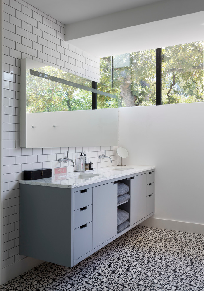 Immagine di una stanza da bagno moderna con lavabo sottopiano, ante lisce, ante grigie, piastrelle bianche e piastrelle diamantate
