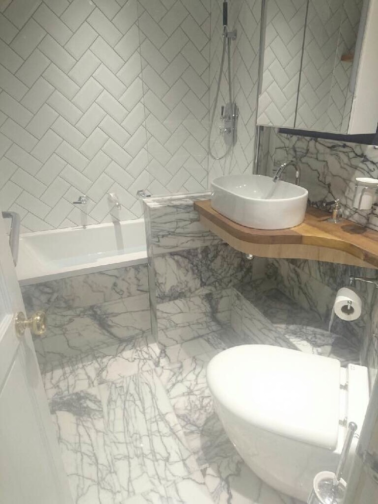 Inspiration för små klassiska badrum för barn, med ett platsbyggt badkar, en dusch/badkar-kombination, en toalettstol med hel cisternkåpa, vit kakel, stenkakel, lila väggar, marmorgolv, ett konsol handfat och träbänkskiva