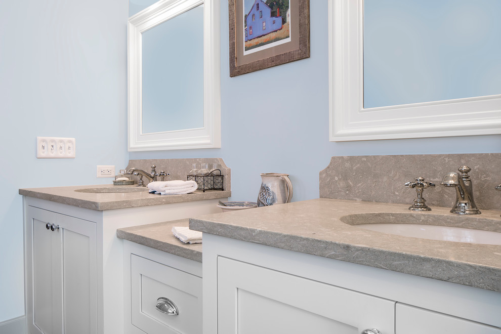 Inredning av ett klassiskt en-suite badrum, med skåp i shakerstil, vita skåp, blå väggar, ett undermonterad handfat och bänkskiva i kalksten