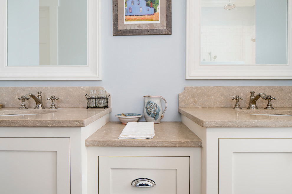 Foto de cuarto de baño principal tradicional renovado con armarios estilo shaker, puertas de armario blancas, paredes azules, suelo de madera en tonos medios, lavabo bajoencimera y encimera de piedra caliza