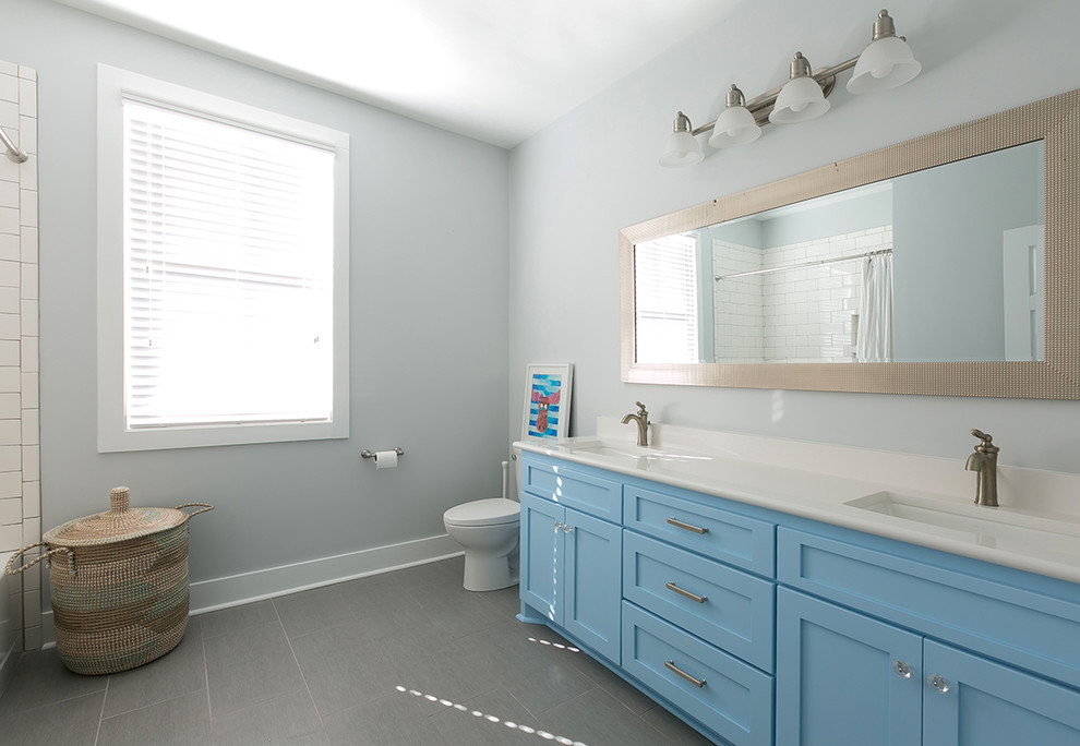 Inspiration for a medium sized traditional family bathroom in Charleston with shaker cabinets, white cabinets, a shower/bath combination, a one-piece toilet, black and white tiles, blue walls and a submerged sink.