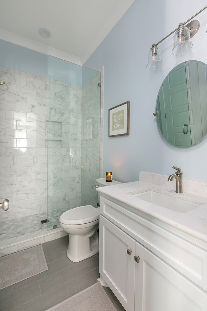Idée de décoration pour une salle de bain tradition de taille moyenne pour enfant avec un placard à porte shaker, des portes de placard blanches, une douche d'angle, WC à poser, un carrelage noir et blanc, un mur bleu et un lavabo encastré.