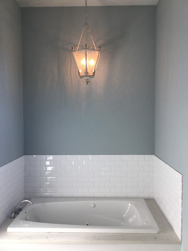 Réalisation d'une grande salle de bain principale tradition avec un placard avec porte à panneau surélevé, des portes de placard grises, un carrelage blanc et un plan de toilette en granite.