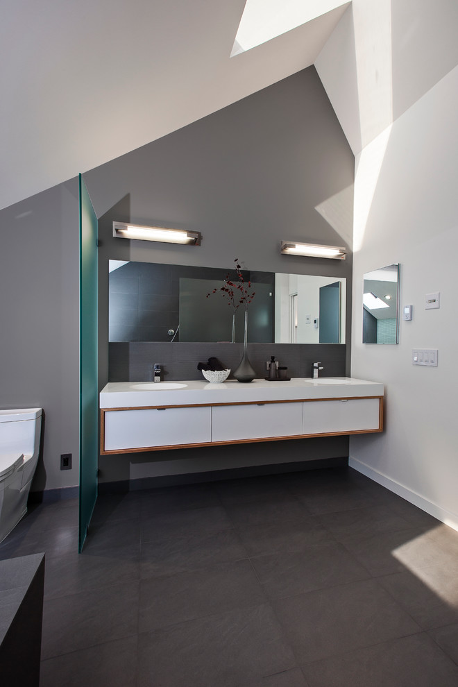 Diseño de cuarto de baño contemporáneo con armarios con paneles lisos, puertas de armario blancas y baldosas y/o azulejos grises