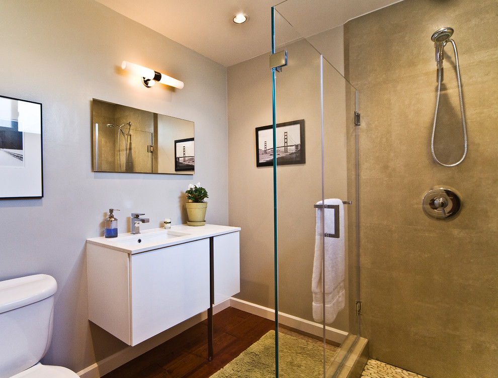 Modernes Badezimmer mit Unterbauwaschbecken, flächenbündigen Schrankfronten, weißen Schränken, Eckdusche, Wandtoilette mit Spülkasten und beigen Fliesen in San Francisco