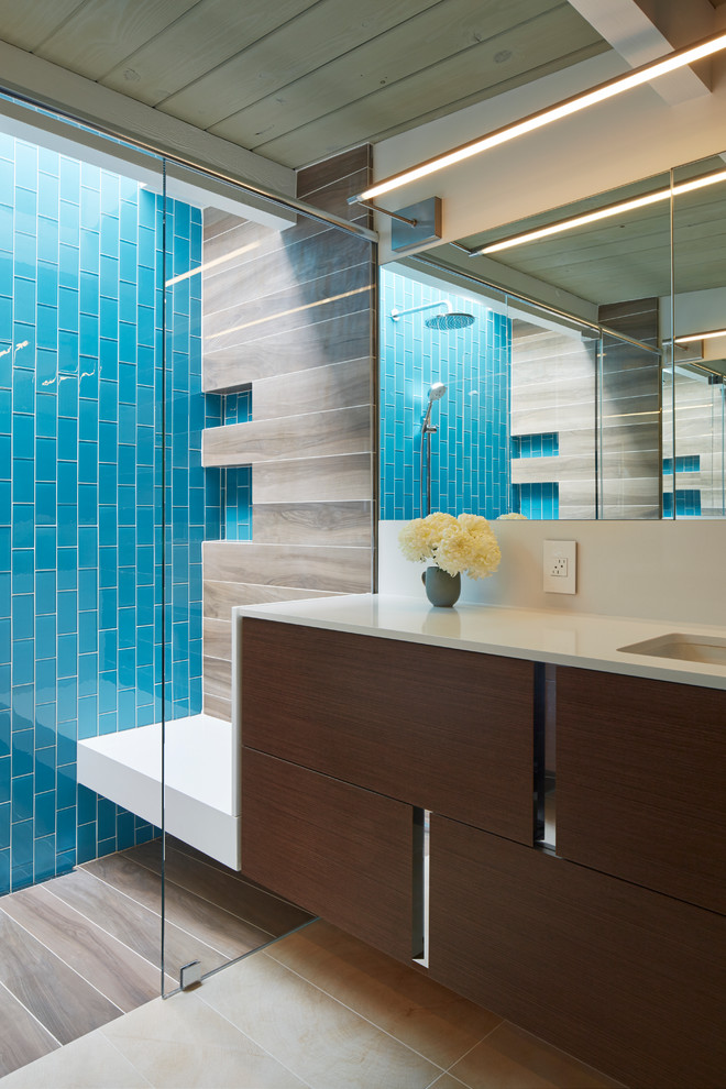 Diseño de cuarto de baño vintage con lavabo bajoencimera, armarios con paneles lisos, puertas de armario de madera en tonos medios, ducha empotrada, baldosas y/o azulejos azules, baldosas y/o azulejos de vidrio y paredes blancas
