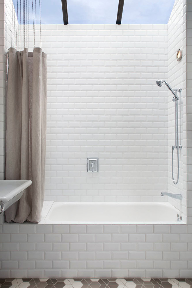 Immagine di una piccola stanza da bagno classica con vasca ad alcova, vasca/doccia, piastrelle bianche, lavabo sospeso, WC monopezzo, piastrelle in ceramica, pareti bianche e pavimento con piastrelle in ceramica