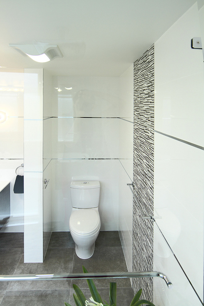Trendy gray tile and ceramic tile bathroom photo in San Francisco with a vessel sink, a two-piece toilet, flat-panel cabinets, black cabinets and quartz countertops